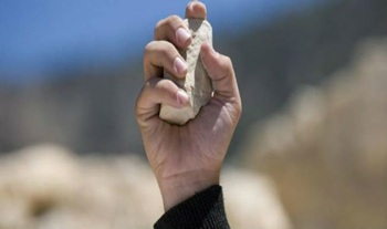 Une main prête à jeter une pierre à une personne qui a péché